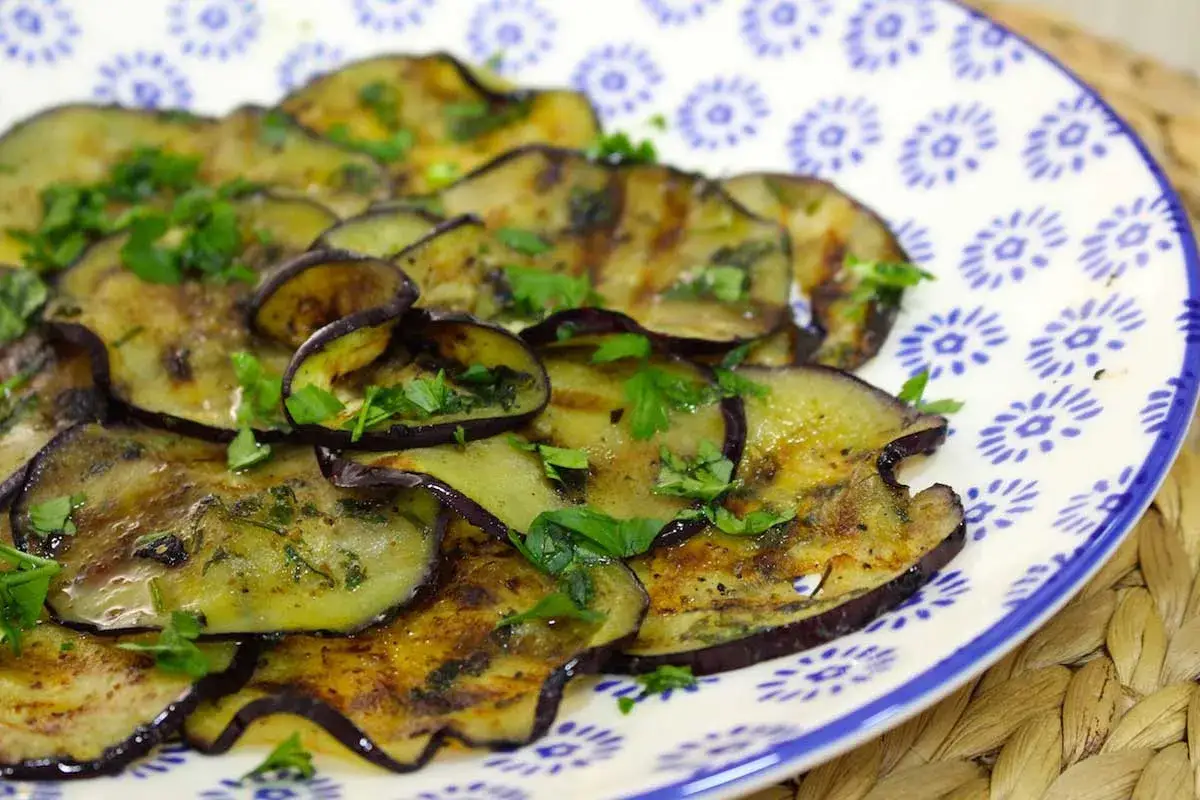 Rodajas de berenjena a la parrilla, tiernas y sabrosas, con perejil fresco. &iexcl;Descubre que se puede comer la berenjena cruda y disfrutar de esta delicia!