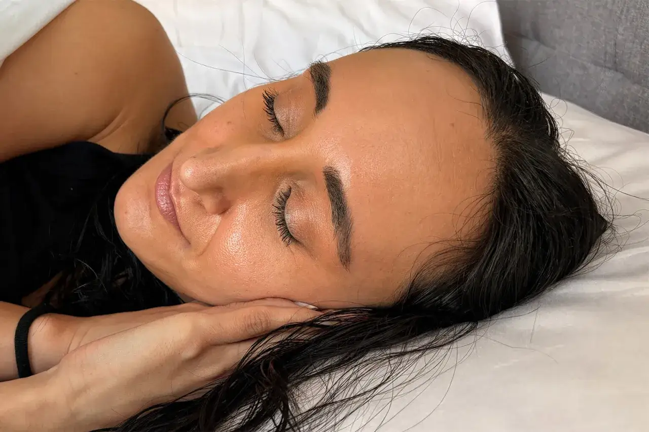 Mujer durmiendo con el pelo mojado, un error com&uacute;n que dice que es malo dormir con el pelo mojado.
