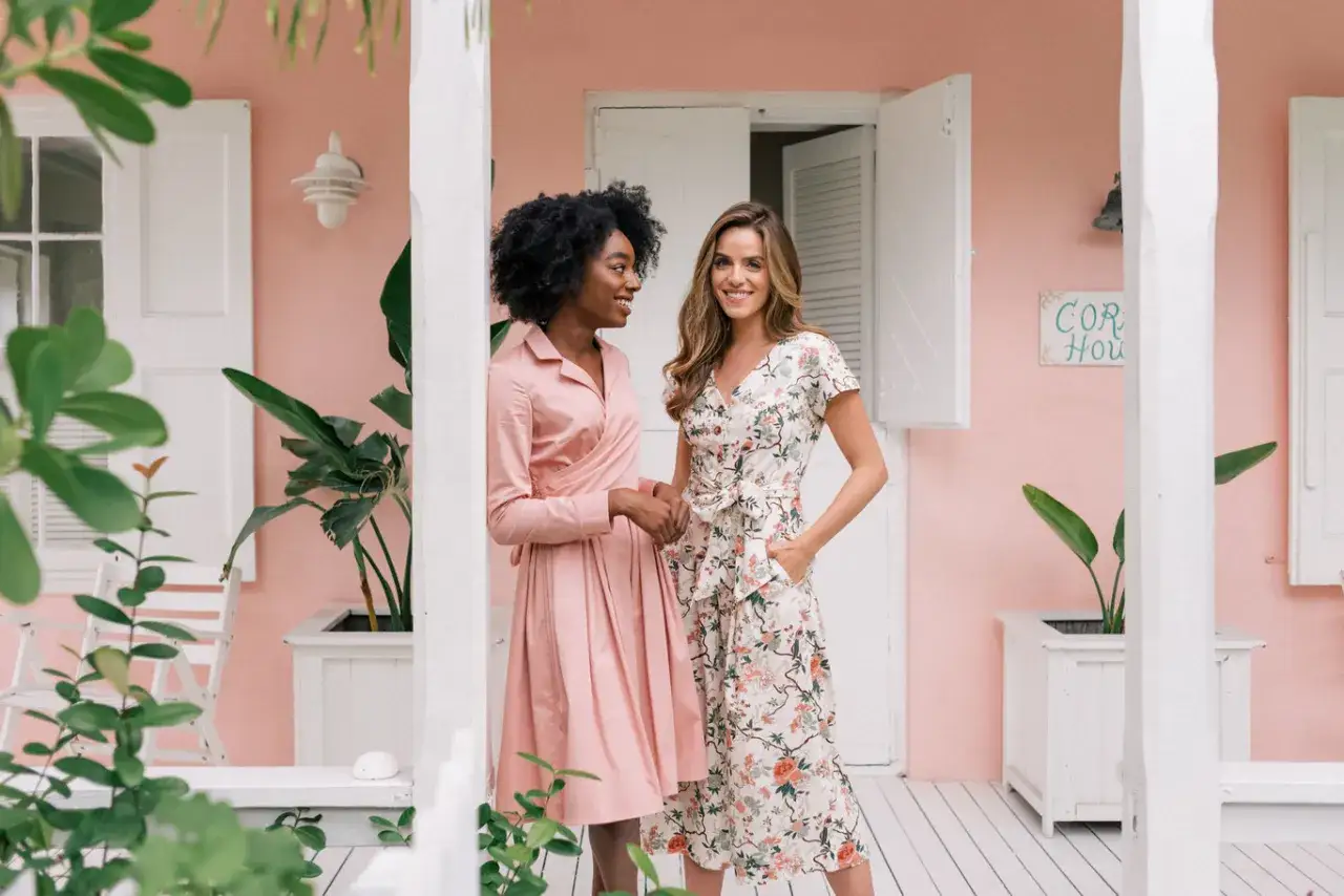 Dos mujeres con vestidos florales y rosados, perfectos para un look smart casual mujer boda.