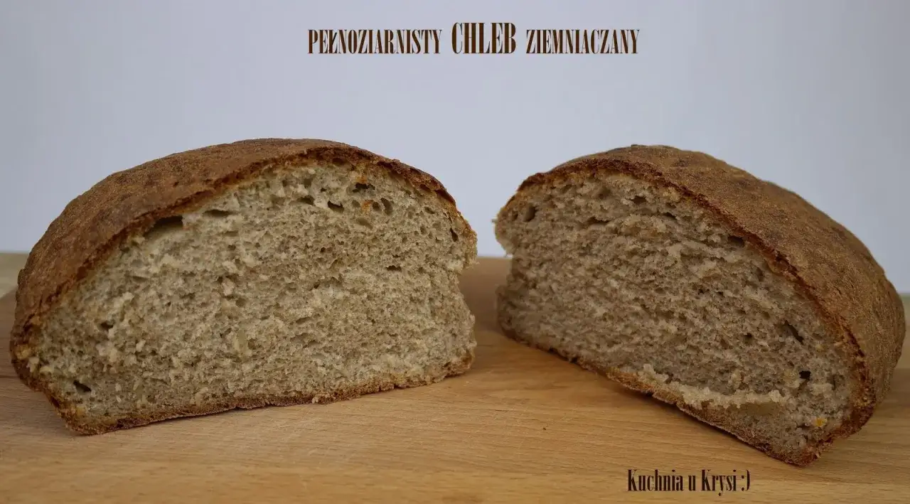 Puszysty chleb z ziemniakami, przekrojony na p&oacute;ł, prezentuje swoje pełnoziarniste wnętrze. Idealny na kanapki.