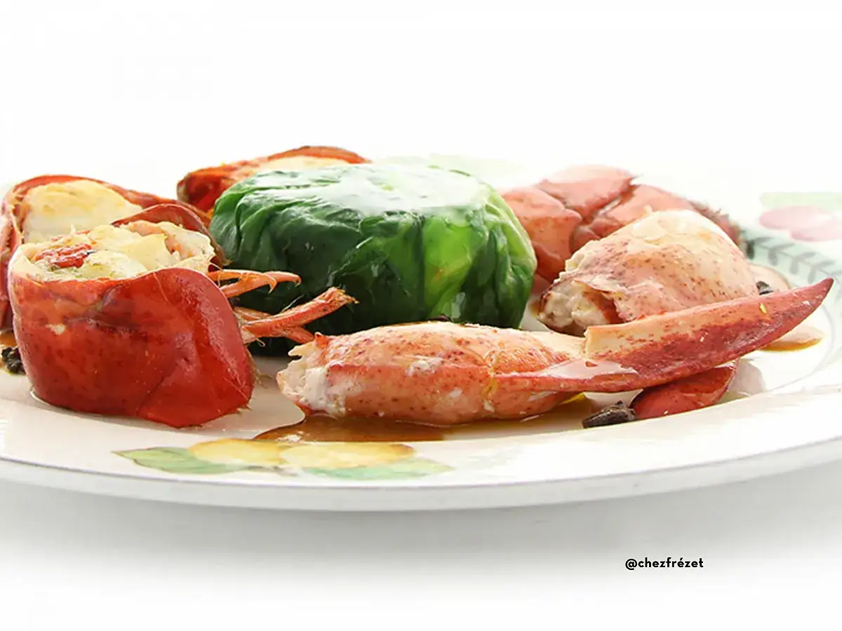 Homard préparé pour une cuisson court bouillon, servi sur une assiette décorée.