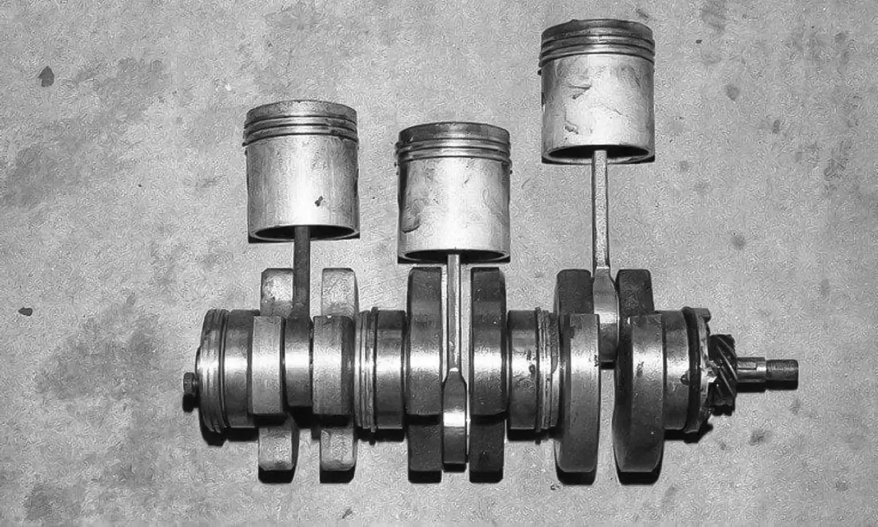 Tres pistones unidos a un cigüeñal, mostrando cómo funcionan las bielas de un coche para convertir el movimiento lineal en rotatorio.