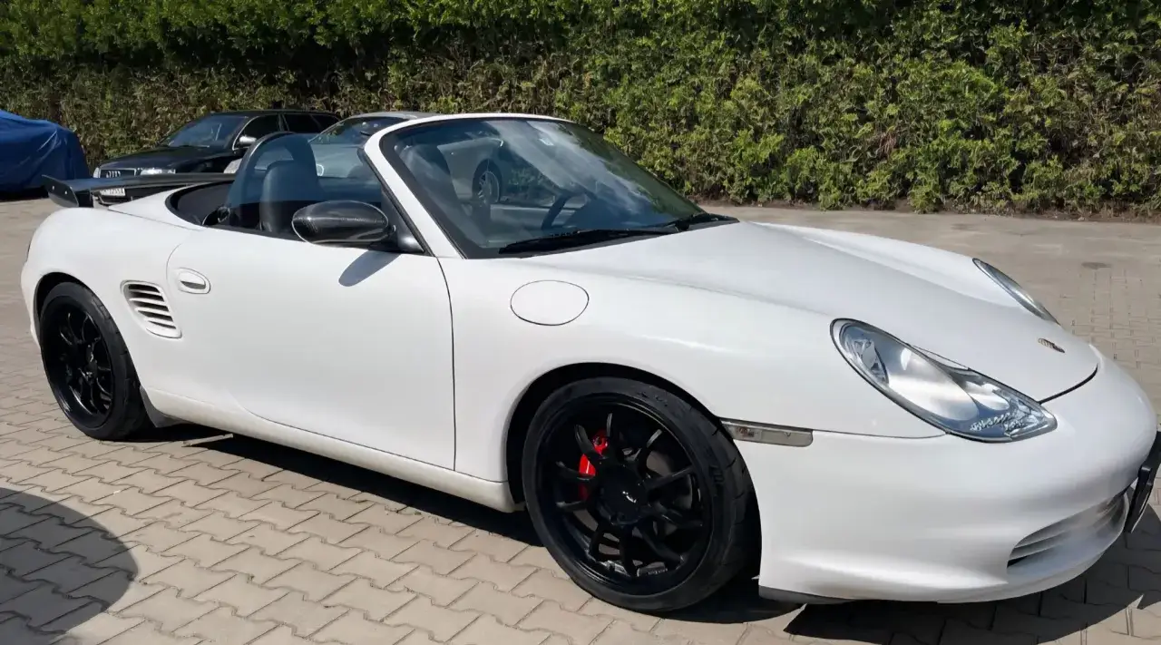 Biały kabriolet Porsche 986 z czarnymi felgami i czerwonymi zaciskami hamulcowymi.
