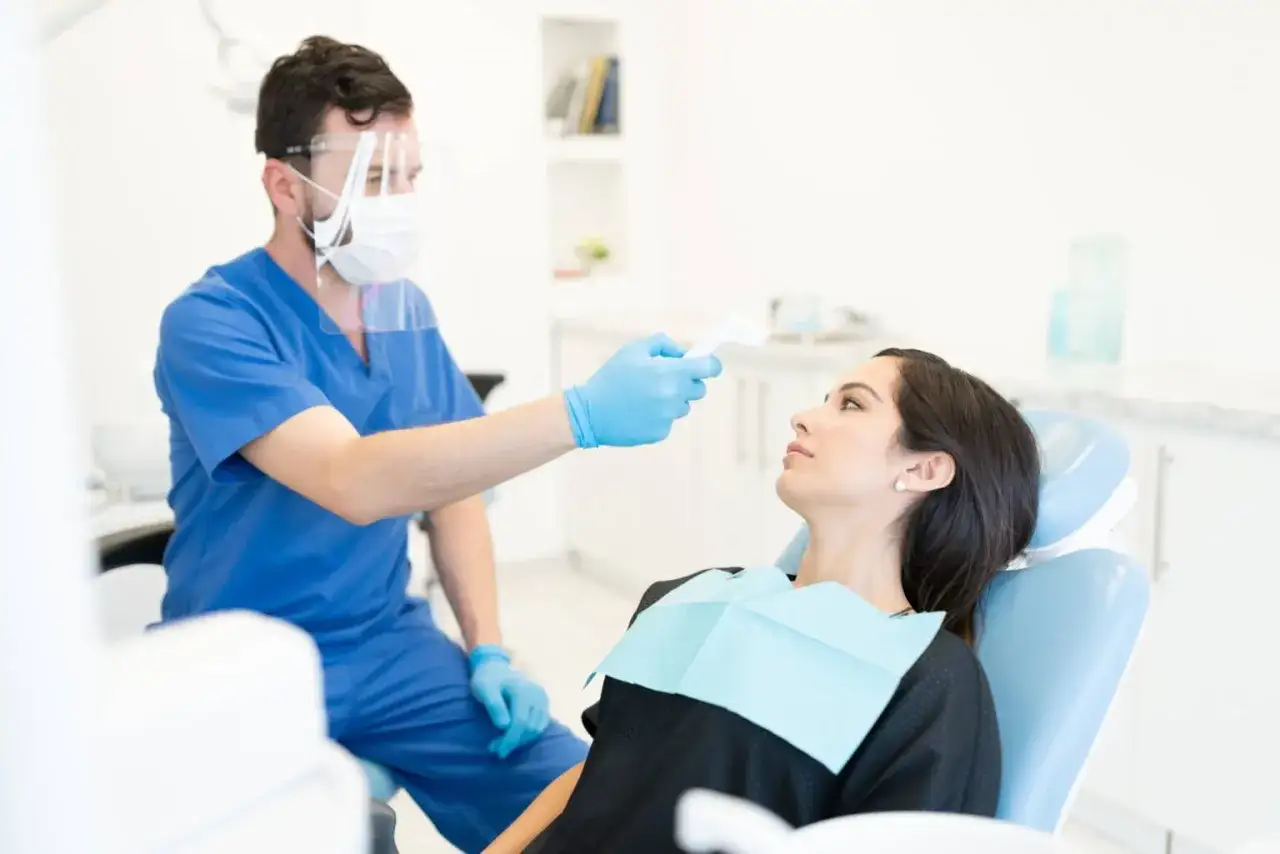 dentysta w nowoczesnym gabinecie stomatologicznym, pracuje z pacjentem