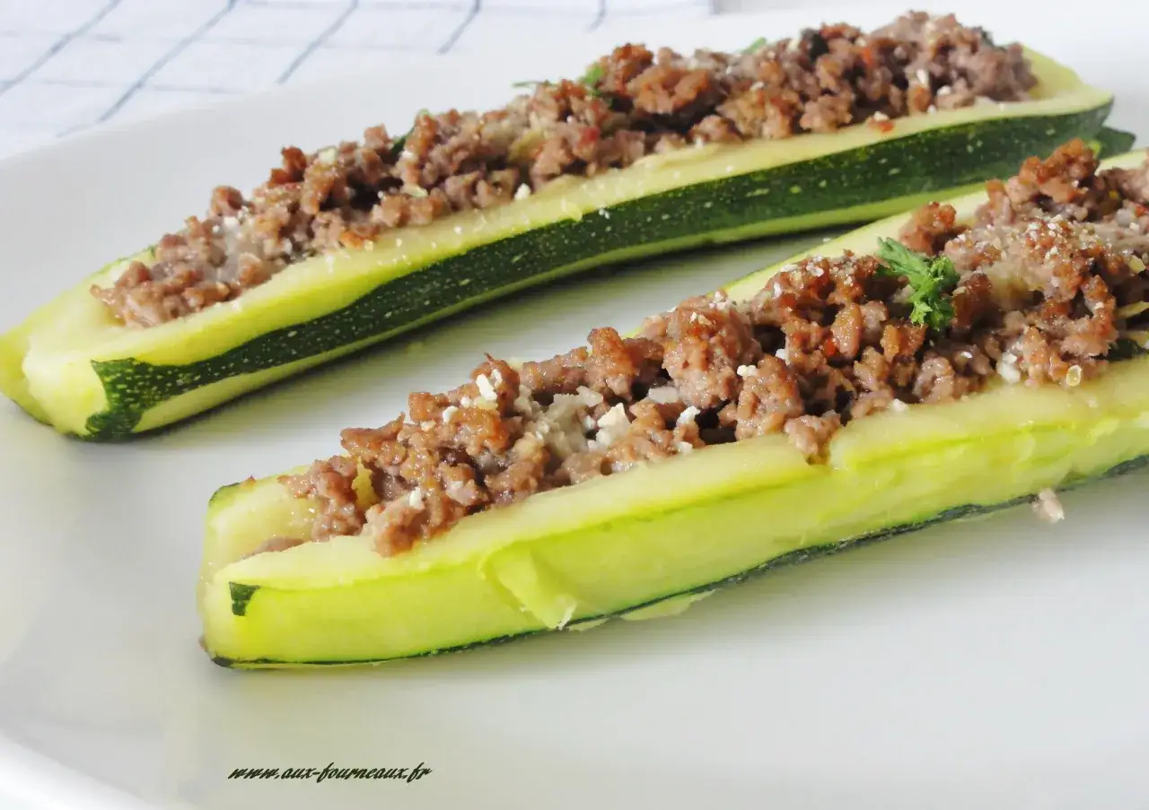 Deux courgettes fendues et garnies d'une farce savoureuse &agrave; la viande hach&eacute;e, saupoudr&eacute;es de fromage r&acirc;p&eacute;. Un d&eacute;lice de courgette farcie pr&ecirc;t &agrave; &ecirc;tre d&eacute;gust&eacute;.