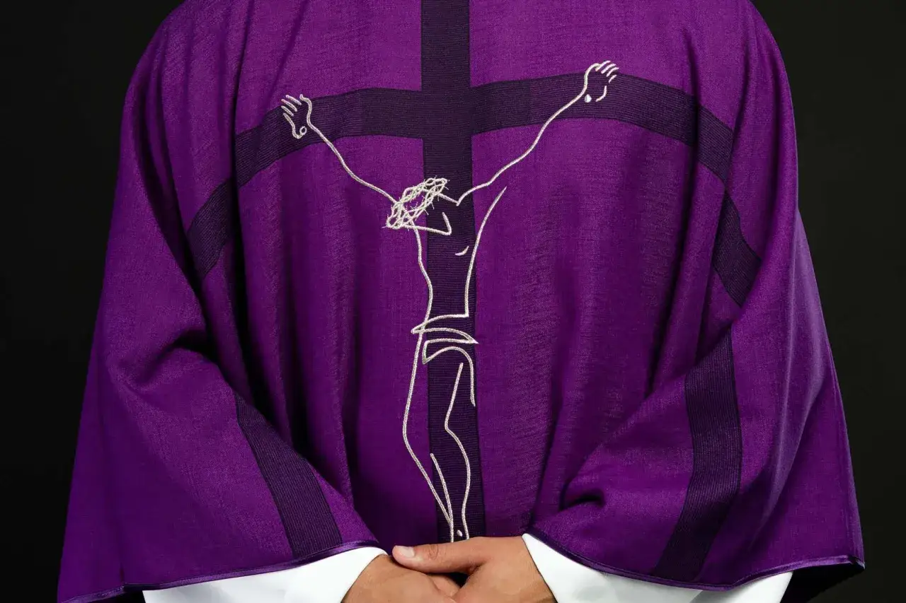 Fioletowa szata liturgiczna z haftowanym krzyżem i postacią Jezusa. Zawitaj ukrzyżowany tekst.