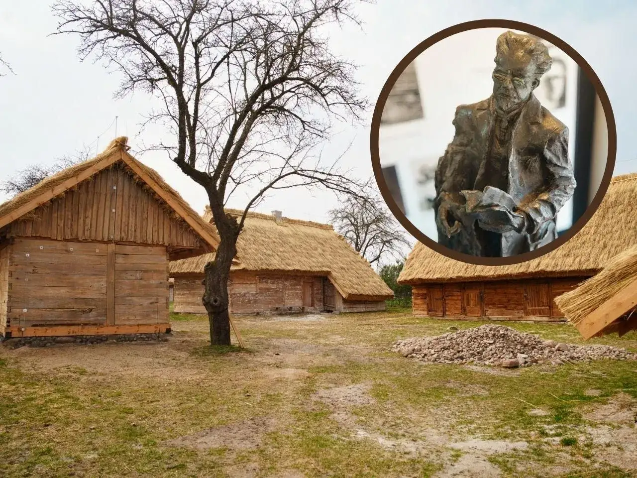 Chłopi, jaka epoka? Drewniane chaty kryte strzechą i pomnik mężczyzny z książką.