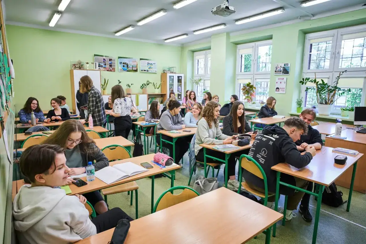 Uczniowie na lekcji, dyskutują, piszą. Może to lekcja o tym, co to wos?