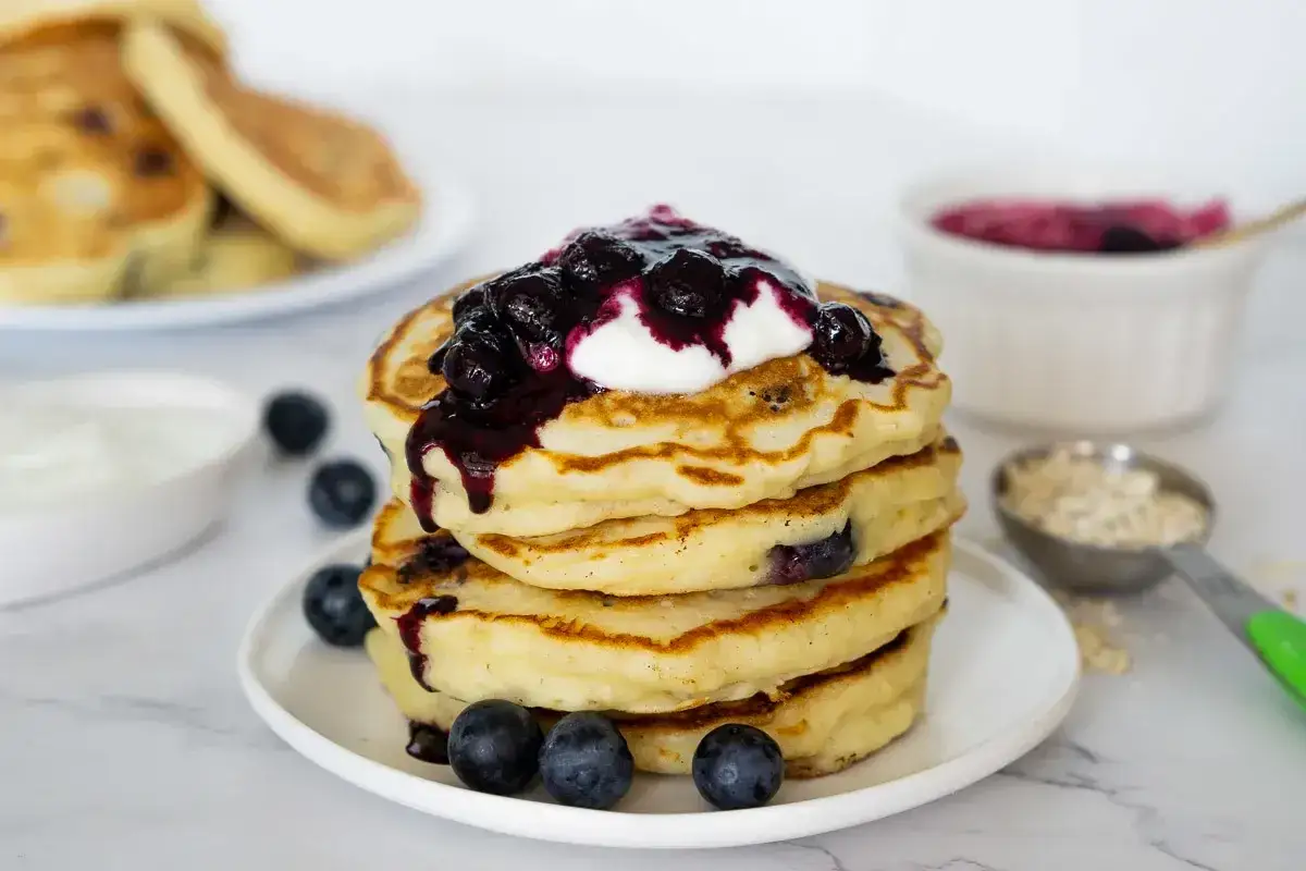 Deliciosas tortitas de avena con ar&aacute;ndanos, cubiertas de yogur y mermelada de frutos rojos. &iexcl;Un desayuno perfecto!