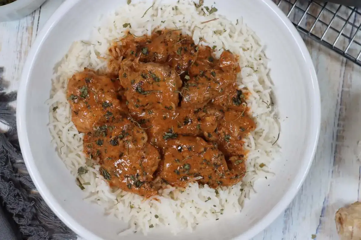 Pyszny kurczak tikka masala w kremowym sosie, podany z ryżem basmati.