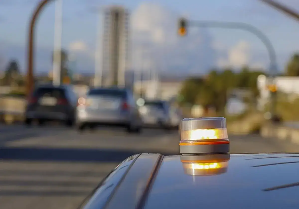 Baliza de emergencia naranja en un coche, lista para se&ntilde;alizar. Los triangulos de prese&ntilde;alizacion son esenciales para la seguridad vial.