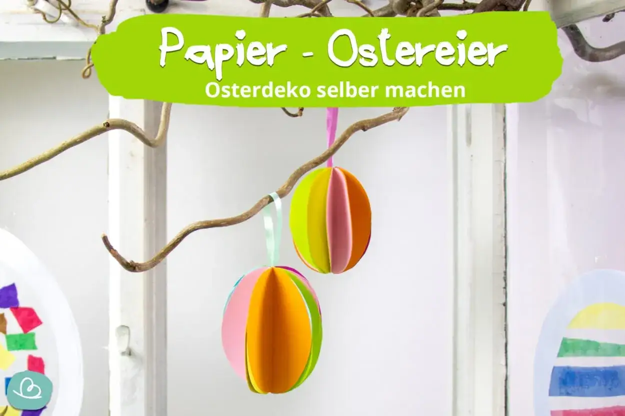 Bunte Papier-Ostereier hängen an einem Ast. Bastelanleitung für Osterdeko mit Papier-Ostereier-Vorlage.