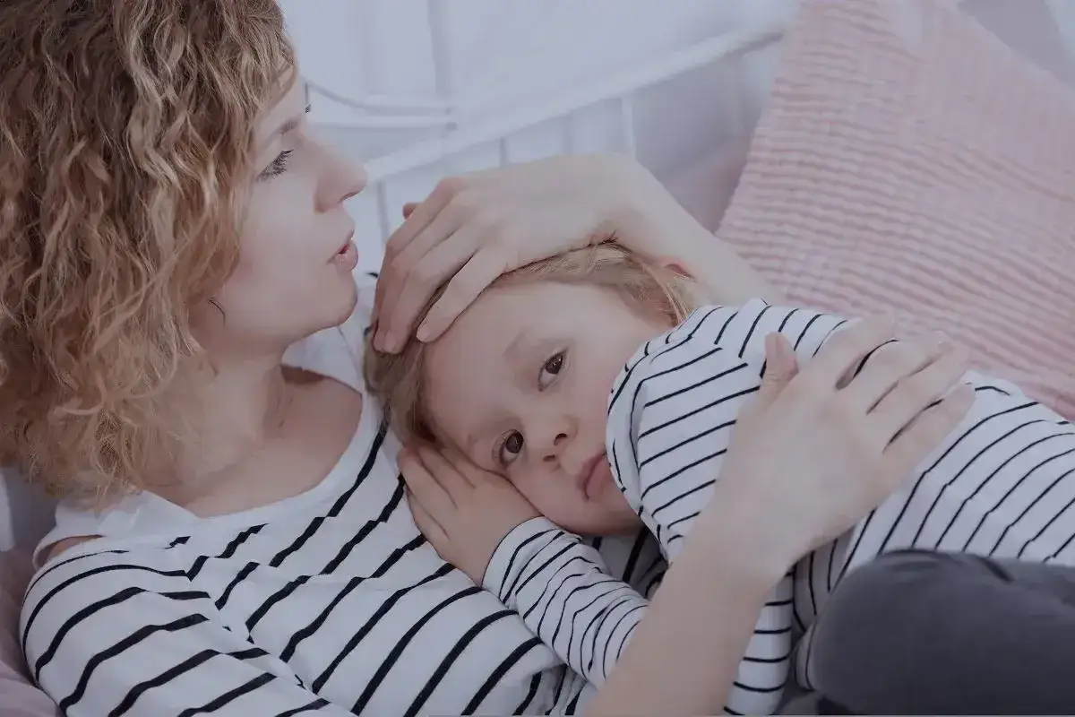 Samotna matka tuli swoje dziecko, szepcząc mu do ucha. Bliskość i troska w ich spojrzeniach.