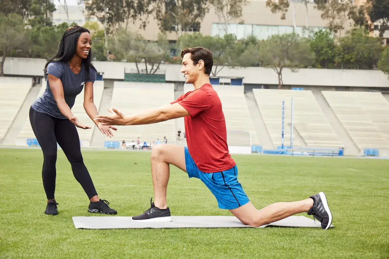 Allenamento con un personal trainer per evitare il sovrallenamento. Rimedi e prevenzione con esercizi mirati su un tappetino all'aperto.