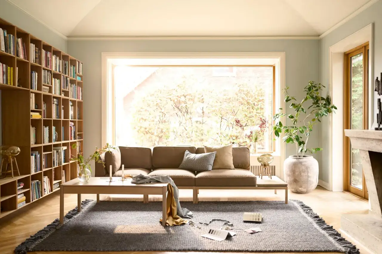 Gemütliche **couch vor heizung** im Wohnzimmer mit Bücherregal, großem Fenster und Kamin.