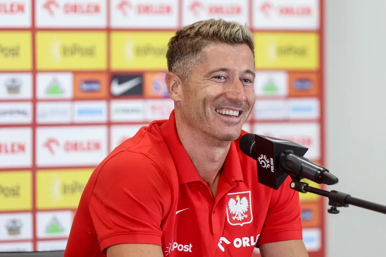 Uśmiechnięty Robert Lewandowski w czerwonej koszulce z orłem. Ile języków zna Robert Lewandowski? Pewnie tyle, ile potrzebuje, by dogadać się z fanami na całym świecie.