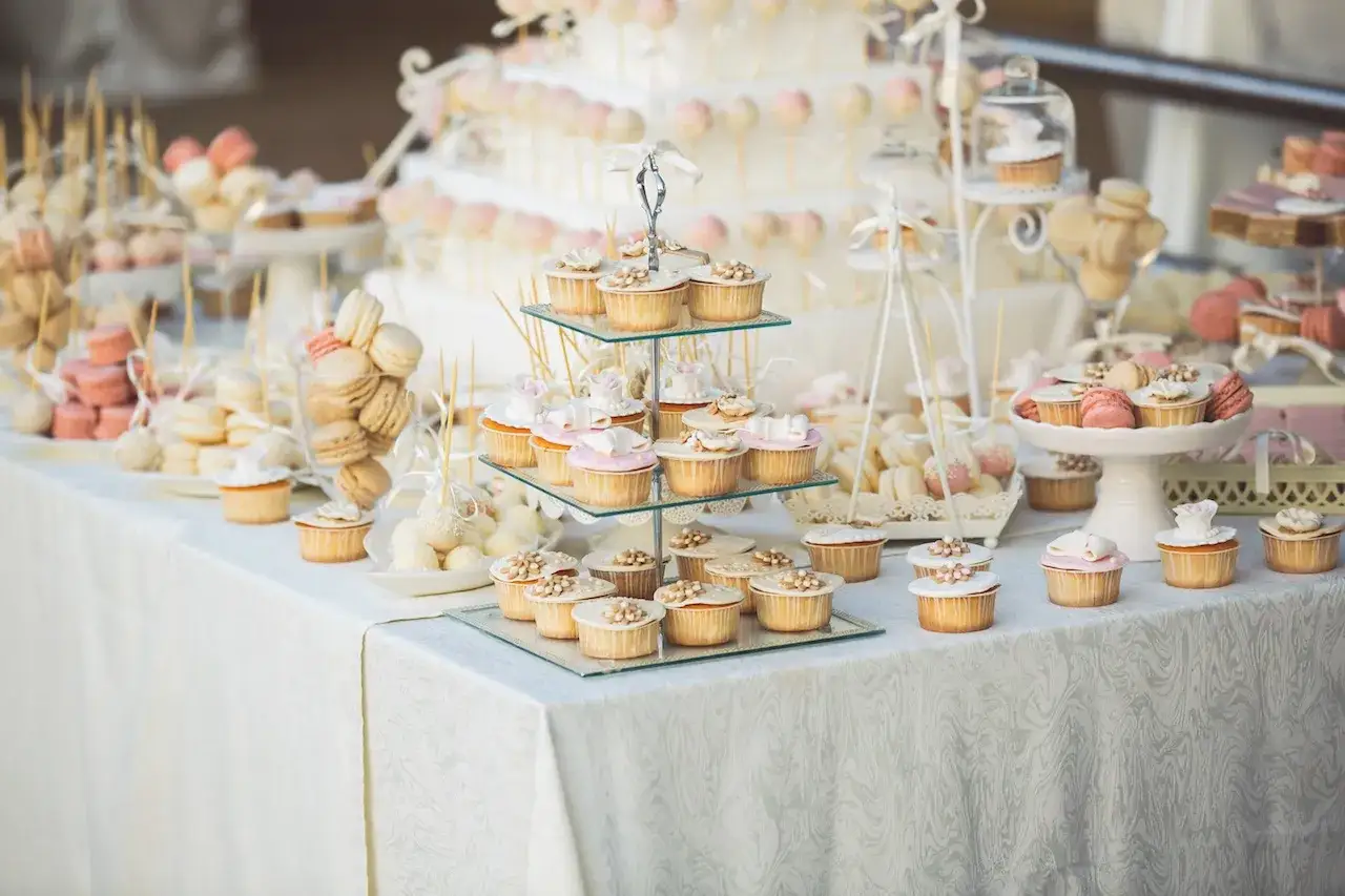 Un buffet de mariage féerique avec une **idée buffet dessert mariage** parfaite : cupcakes, macarons, cake pops et une pièce montée élégante.