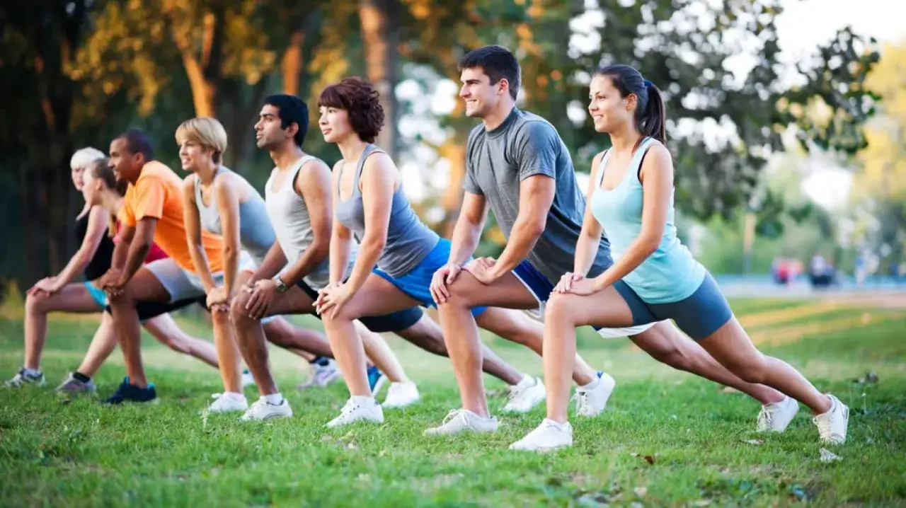 Un gruppo di persone fa stretching all'aperto. Lo sport è un valido alleato contro la depressione, migliorando umore e benessere.