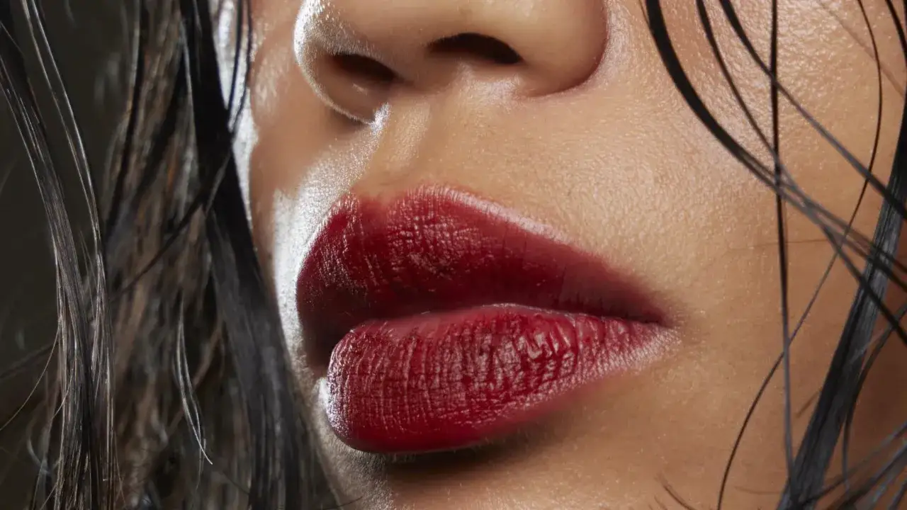 Labbra sensuali con rossetto color ciliegia, un look audace che esalta la bellezza naturale.