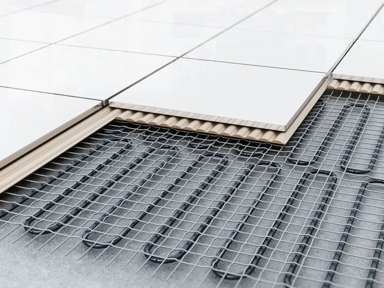 Coupe d'un sol carrelé révélant le système de chauffage au sol hydraulique, avec des tuyaux noirs en U sur une grille métallique sous des couches isolantes et des carreaux blancs.