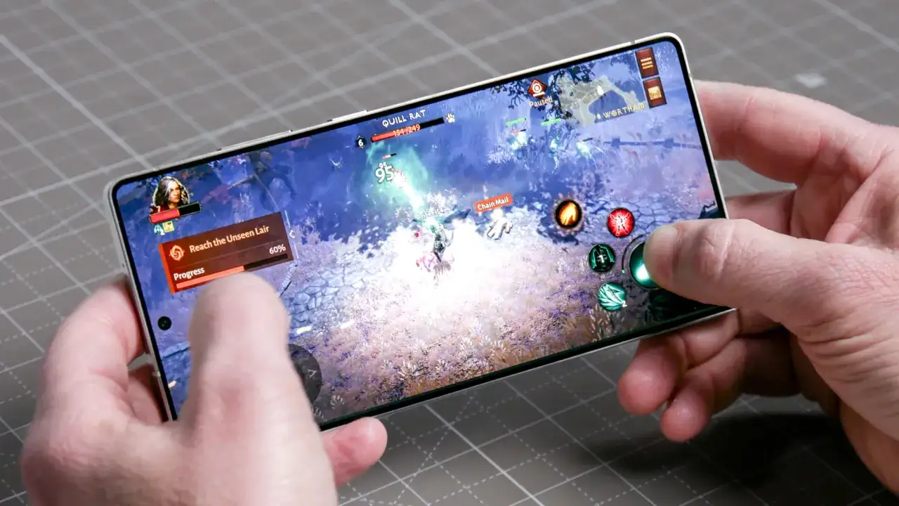 Ręce trzymają smartfon, na którym widać dynamiczną grę akcji. To świetny przykład top gry na androida, gdzie gracz walczy z potworami.