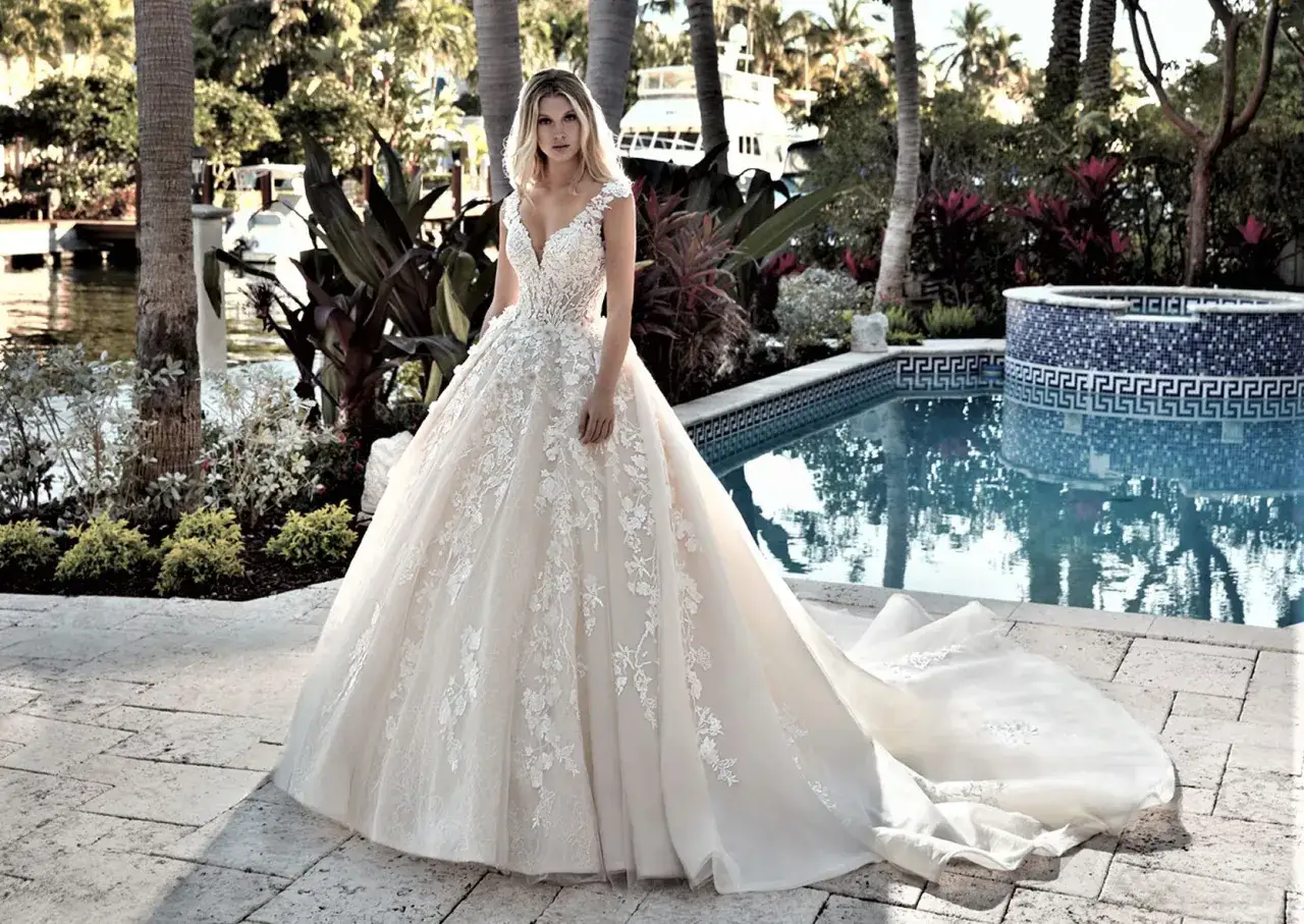 Traumhaftes Brautkleid aus zartem Tüll mit floralen Applikationen, das sich elegant über den Boden legt.