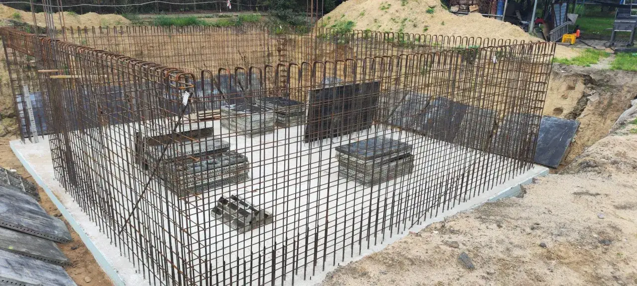 Zbrojenie fundamentów i płyta betonowa na budowie.