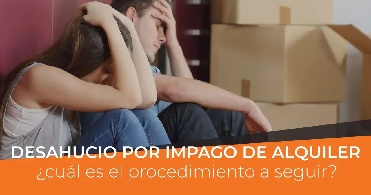 Pareja angustiada sentada entre cajas, enfrentando la enervaci&oacute;n por desahucio fuera de plazo.
