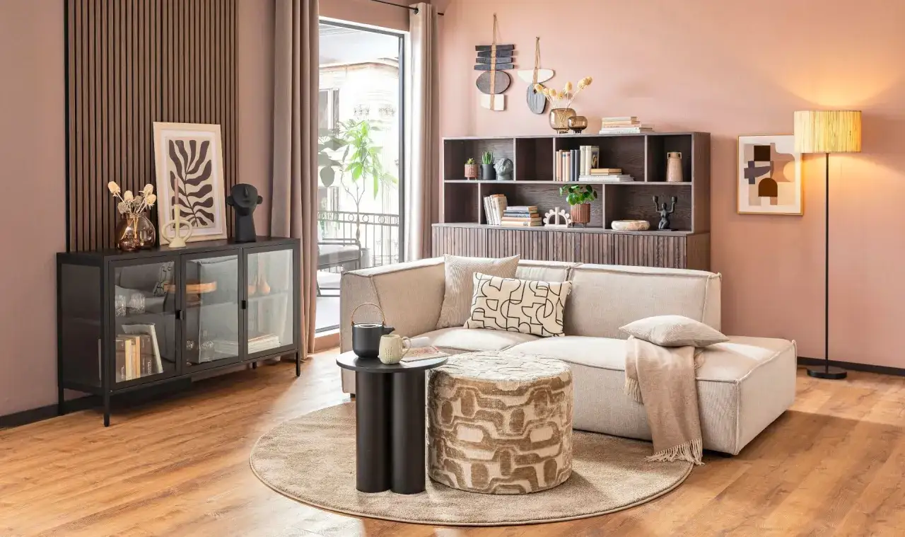 Gemütliche Kaffee Ecke Ideen: Ein beiger Sofa mit Kissen, ein gemusterter Hocker und ein Beistelltisch laden zum Verweilen ein.
