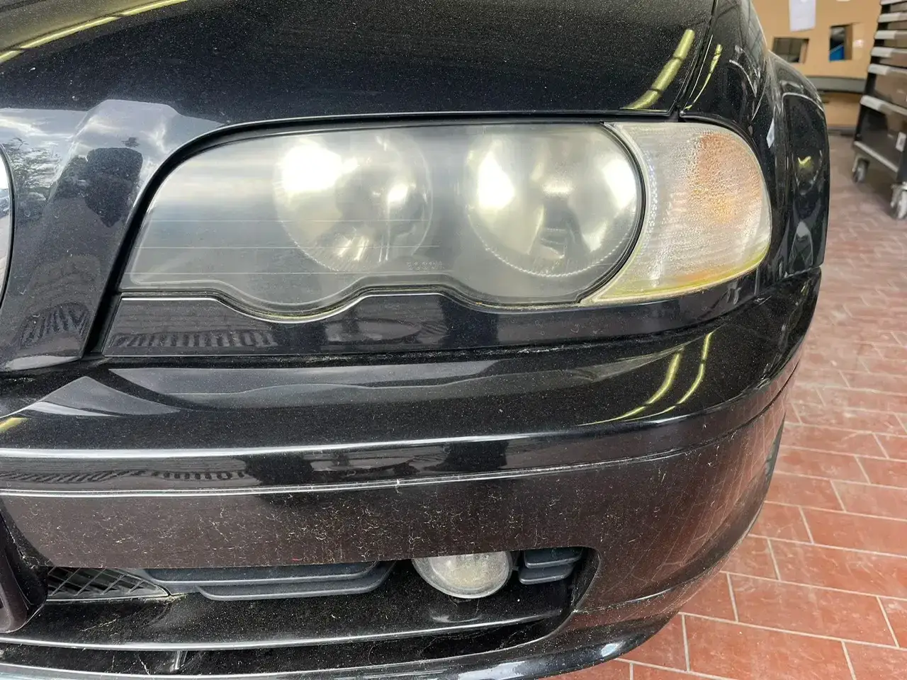 En svart bil med dimmiga str&aring;lkastare. Str&aring;lkastarna &auml;r gulnade och grumliga, vilket ger ett tr&ouml;tt intryck.
