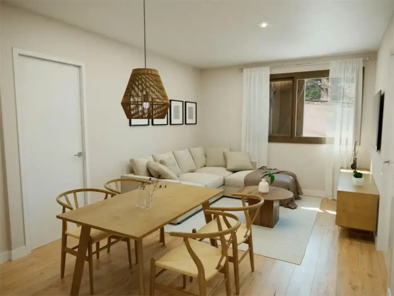 Comedor y salón de una casa en Sallent, con mesa de madera, sofá seccional beige y lámpara de mimbre.