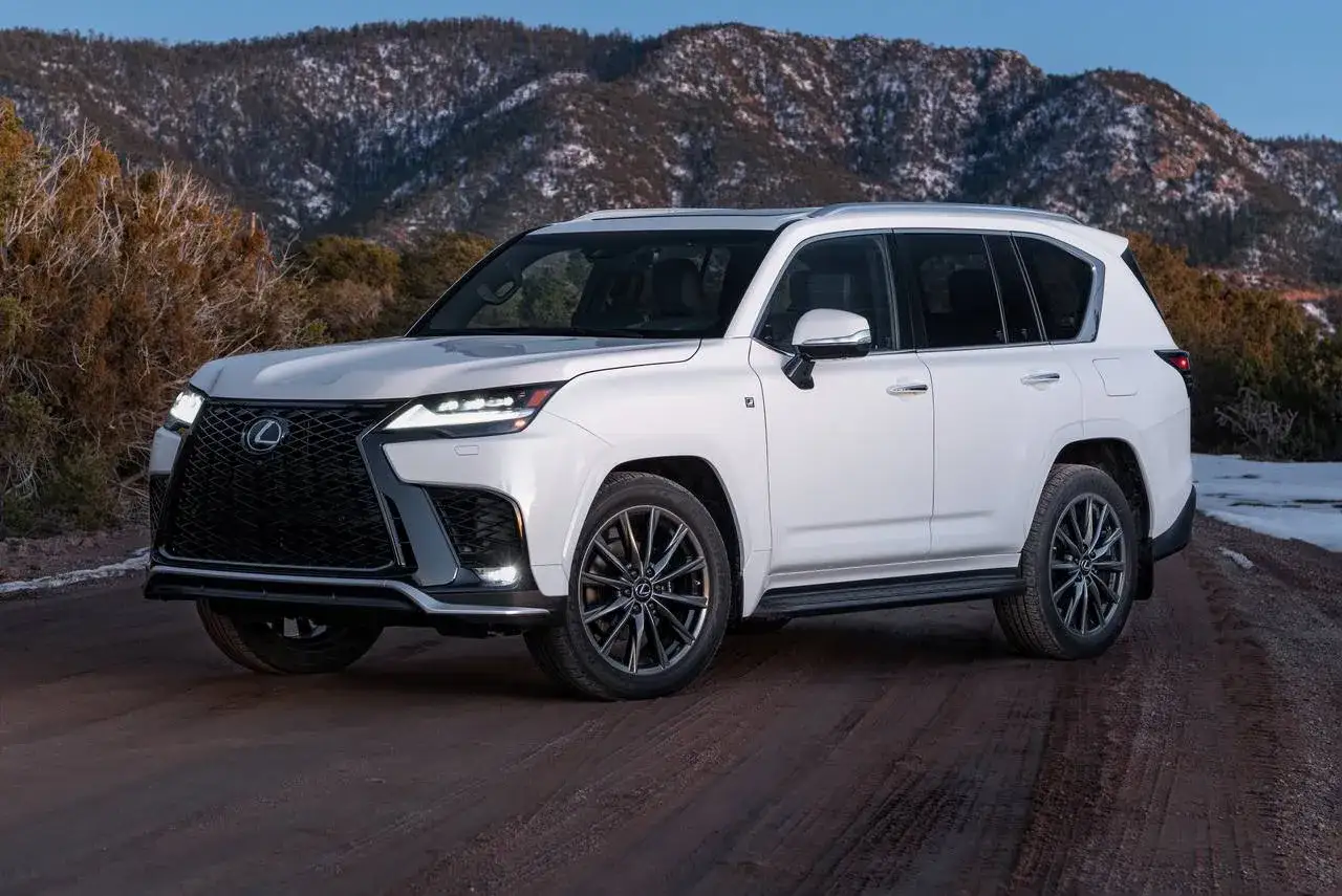 Biały Lexus LX 600 na drodze wśród ośnieżonych gór.