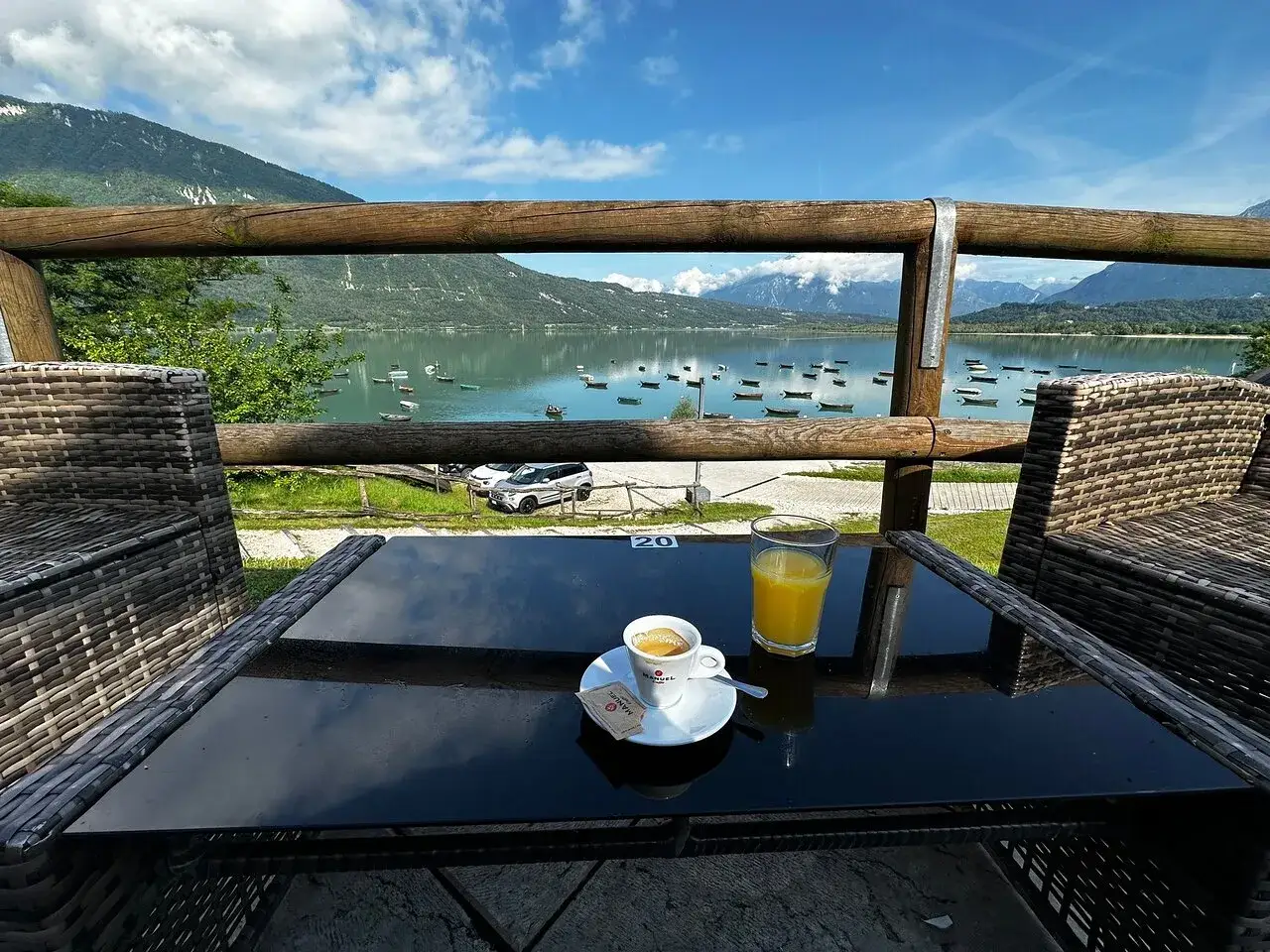 Tavolino con caff&egrave; e succo d'arancia, vista sul lago di Santa Croce dove mangiare.