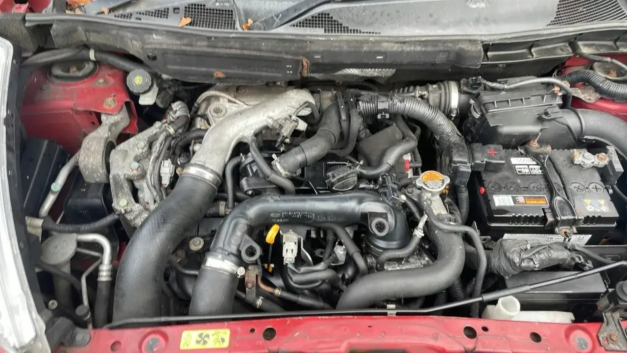Silnik benzynowy 1.6 w Nissan Juke, widoczny pod maską, z widoczną turbosprężarką i elementami układu dolotowego.