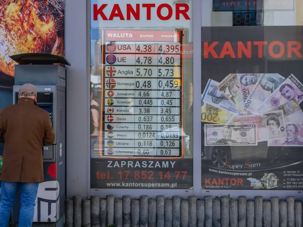 Kantor wymiany walut z cennikiem. Najdroższa waluta w Europie to funt brytyjski, widoczny na zdjęciu obok dolar&oacute;w i innych walut.