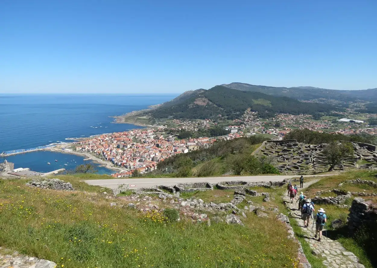 Wanderer erkunden die antiken Ruinen von Castro de Santa Trega mit Blick auf die K&uuml;stenstadt A Guarda an der Costa Verde, Portugal.