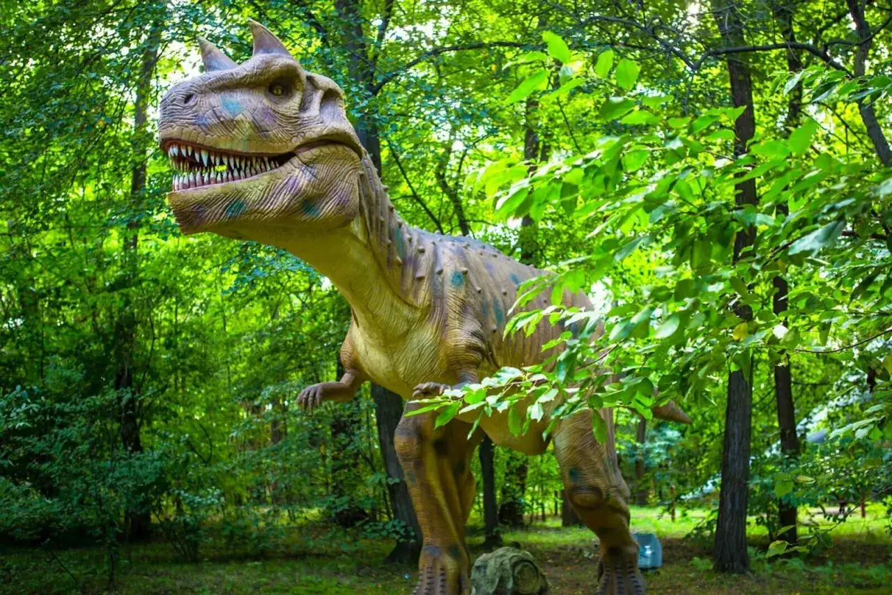 W parku ruchomych dinozaurów czeka na Ciebie groźny T-Rex wśród bujnej zieleni.