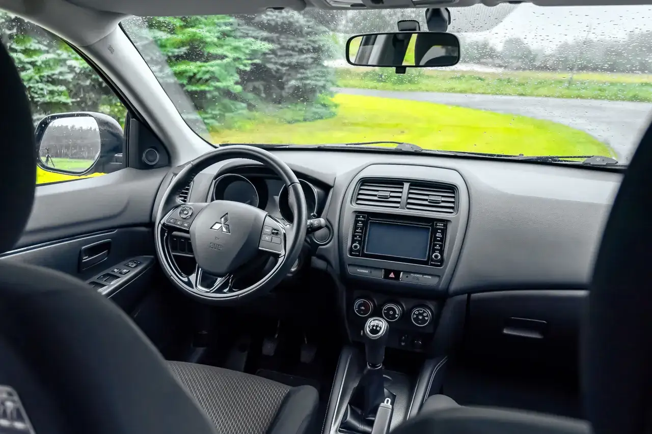 Wnętrze Mitsubishi ASX, deska rozdzielcza z ekranem, kierownicą i dźwignią biegów. Wiele pozytywnych mitsubishi asx opinie.