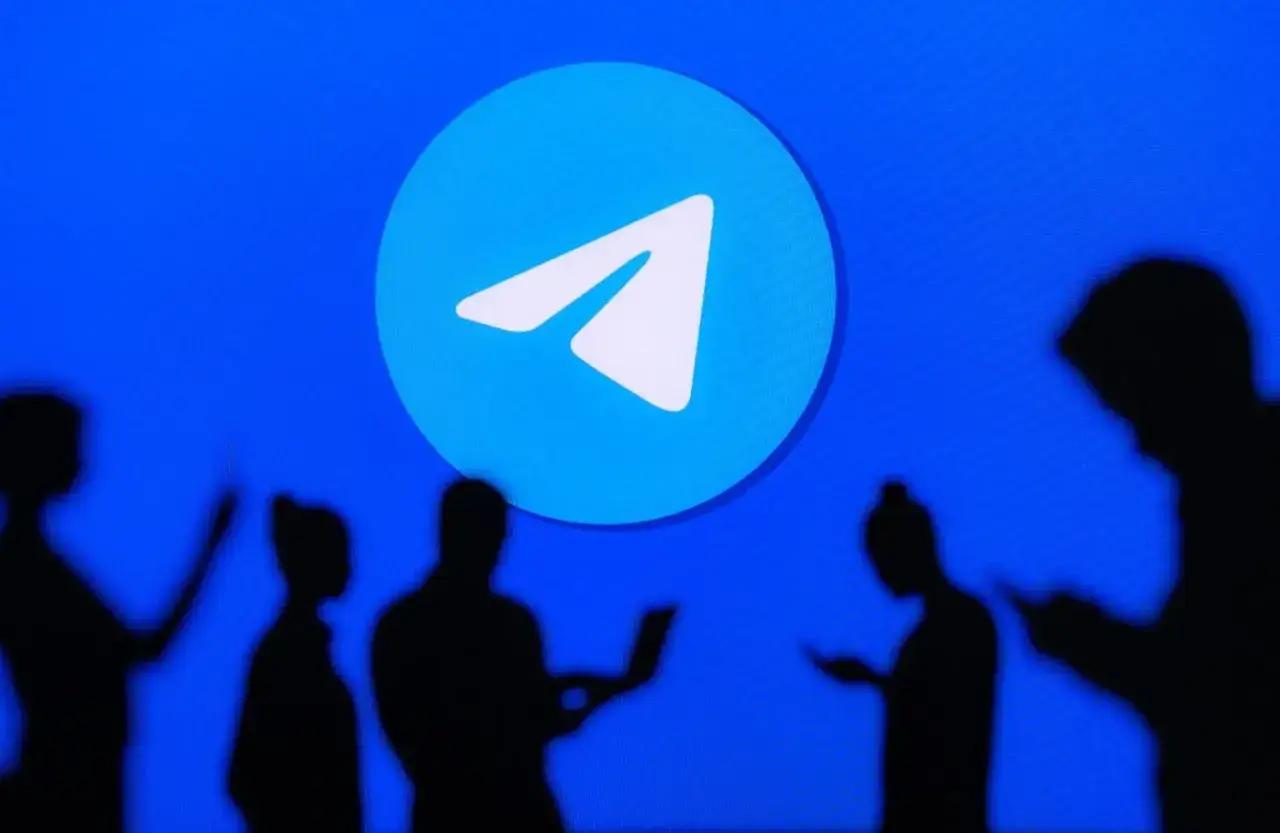 Ludzie w cieniach patrzą na logo Telegramu. Czy telegram jest bezpieczny? To pytanie nurtuje wielu użytkowników.