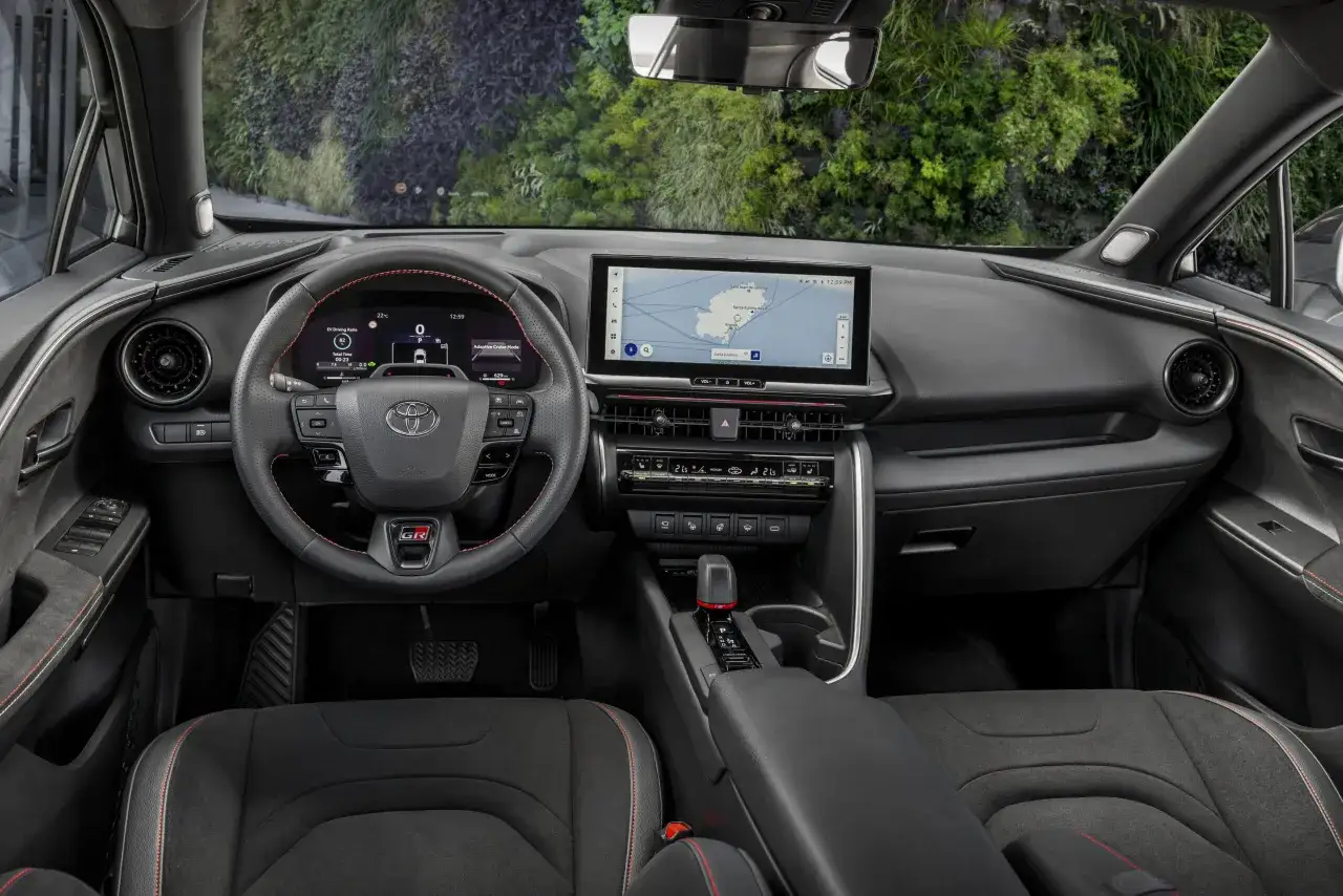 Wnętrze Toyota CHR 2024 z ekranem nawigacji, cyfrowymi zegarami i sportową kierownicą GR.