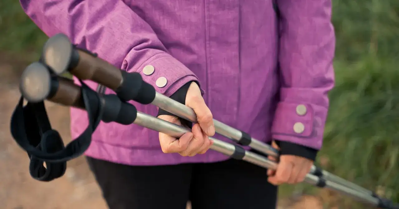 Różowa kurtka, dłonie trzymające kije do nordic walking. Po miesiącu regularnych treningów widać pierwsze efekty.