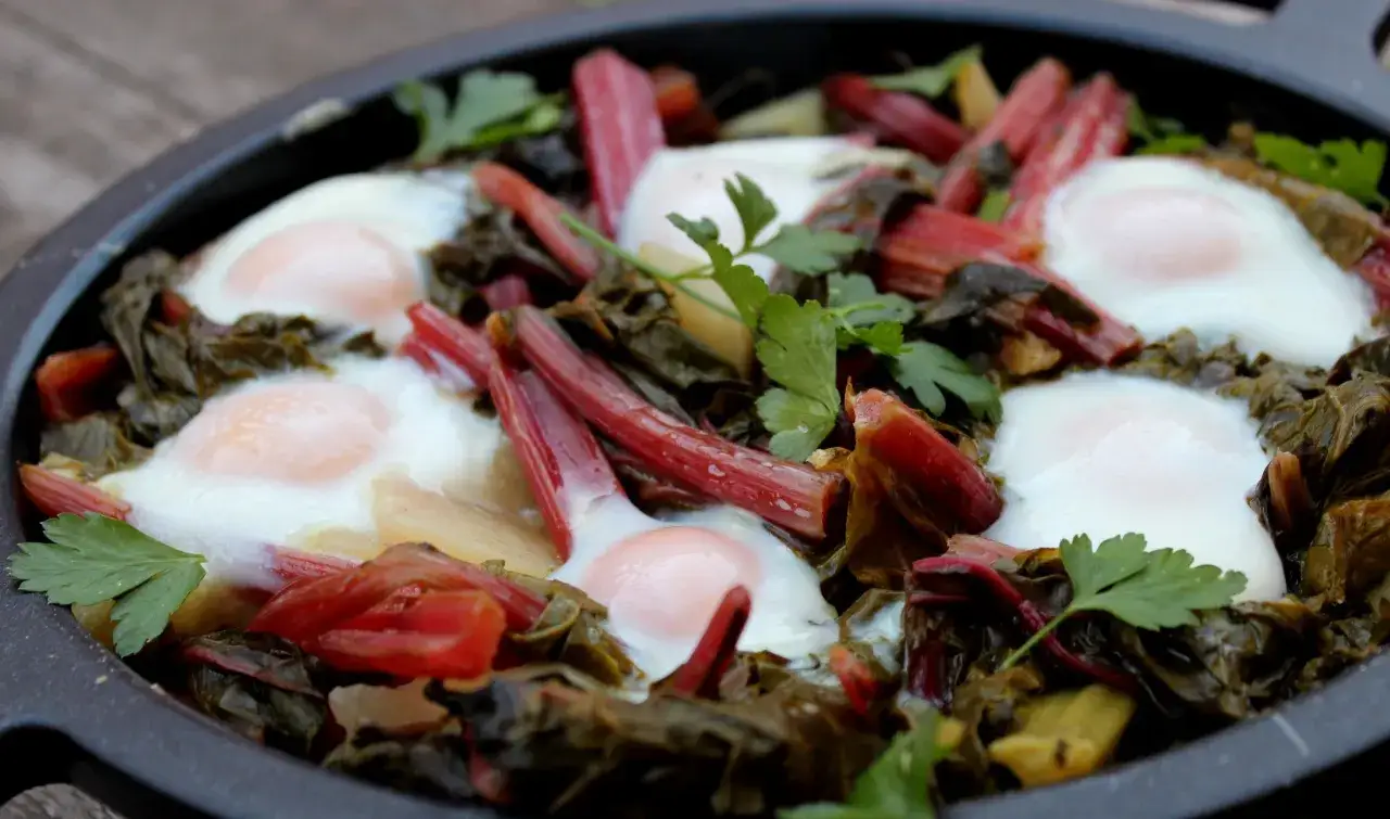 Huevos escalfados sobre acelgas y tallos rojos, una de las muchas recetas con acelgas.