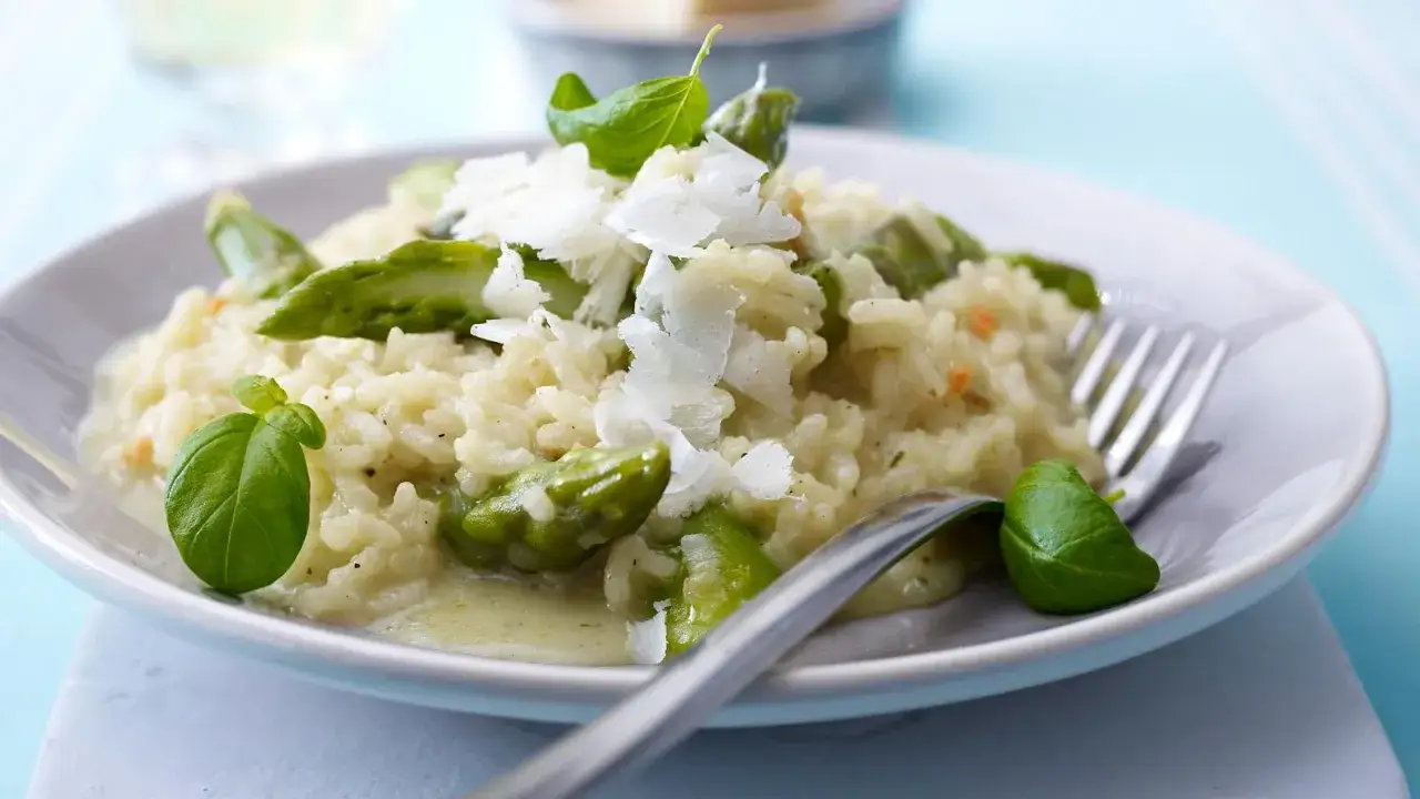 Cremiges Risotto mit frischem Spargel, garniert mit Parmesan und Basilikum. Ein Genuss für jeden Gaumen.