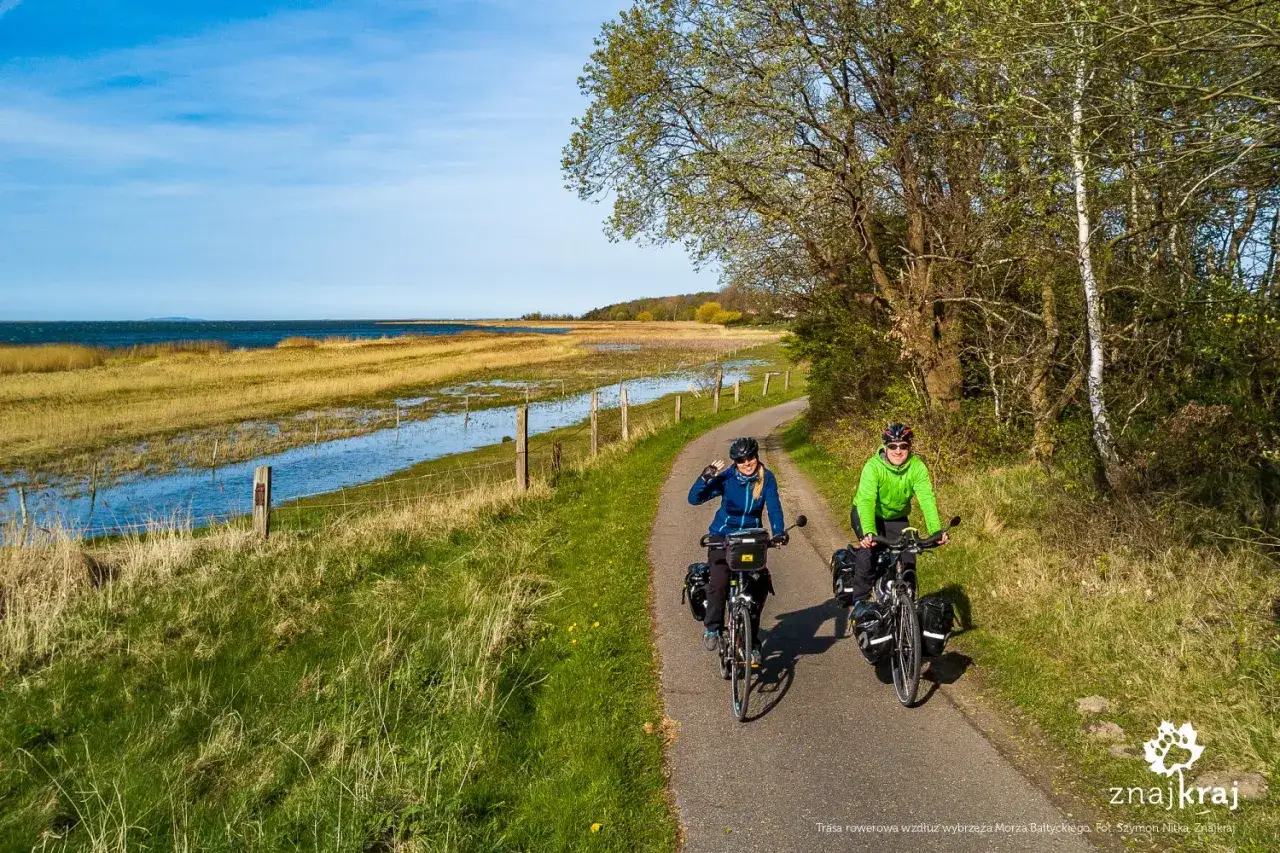 Para na rowerach, na trasie velo 10, cieszy się pięknym widokiem na morze i łąki.