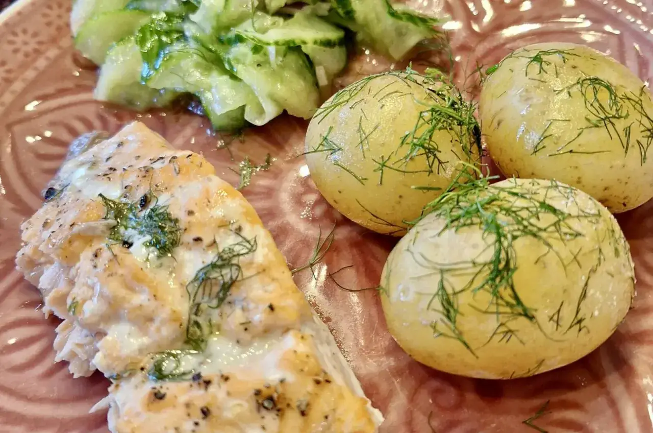 Saftiges Lachsforellenfilet aus dem Backofen, serviert mit Salzkartoffeln und Gurkensalat. Ein k&ouml;stliches Gericht!
