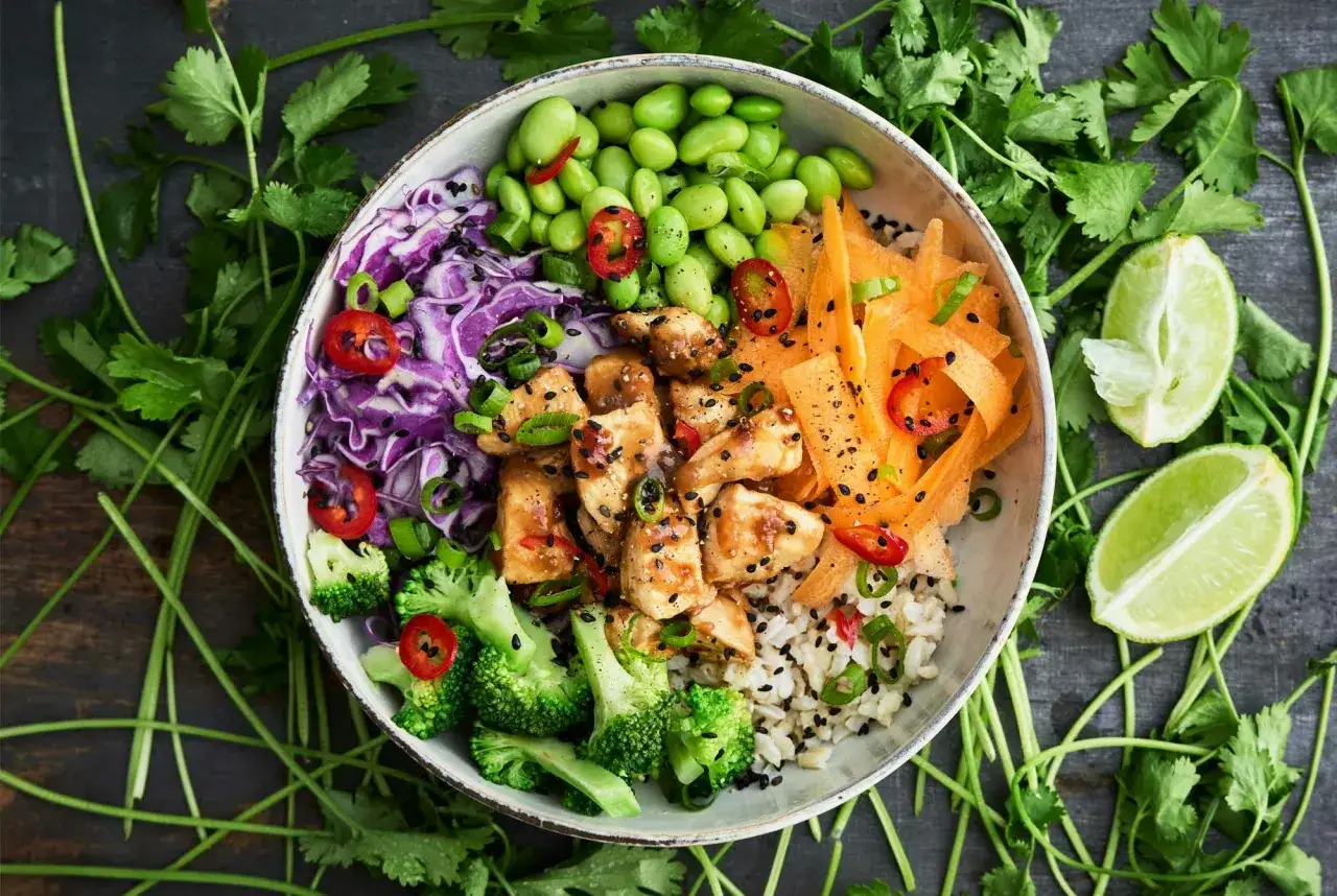 En färgstark bowl med kyckling, ris, broccoli, edamamebönor, morötter och rödkål. Perfekt för bowls recept!