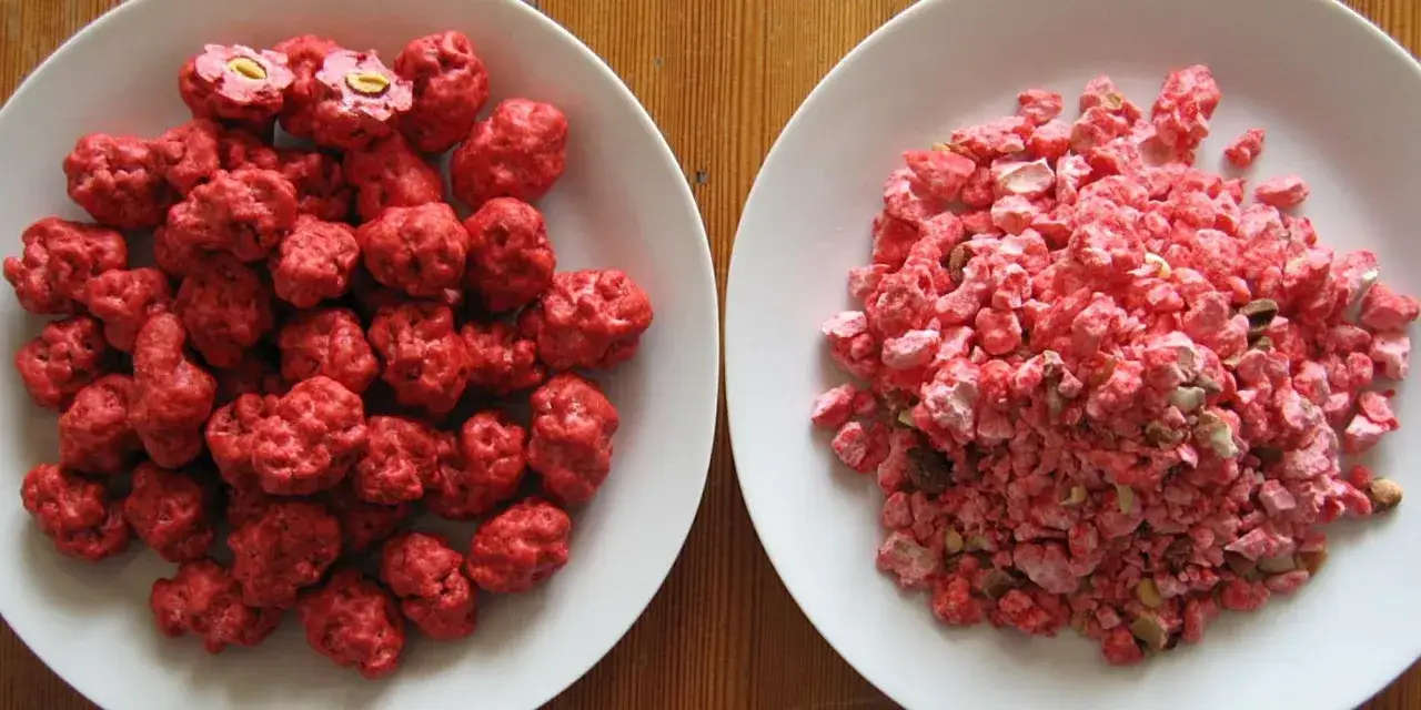Deux assiettes de praline rose : une avec des bonbons entiers, l'autre avec des éclats.