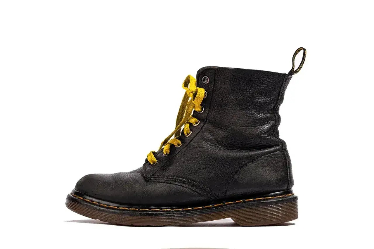 Bota negra de cuero con cordones amarillos. Su diseño robusto y el material hacen que el cuero sea impermeable, ideal para cualquier aventura.