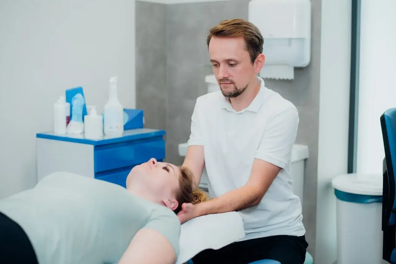 fizjoterapeuta pracuje z pacjentem na macie