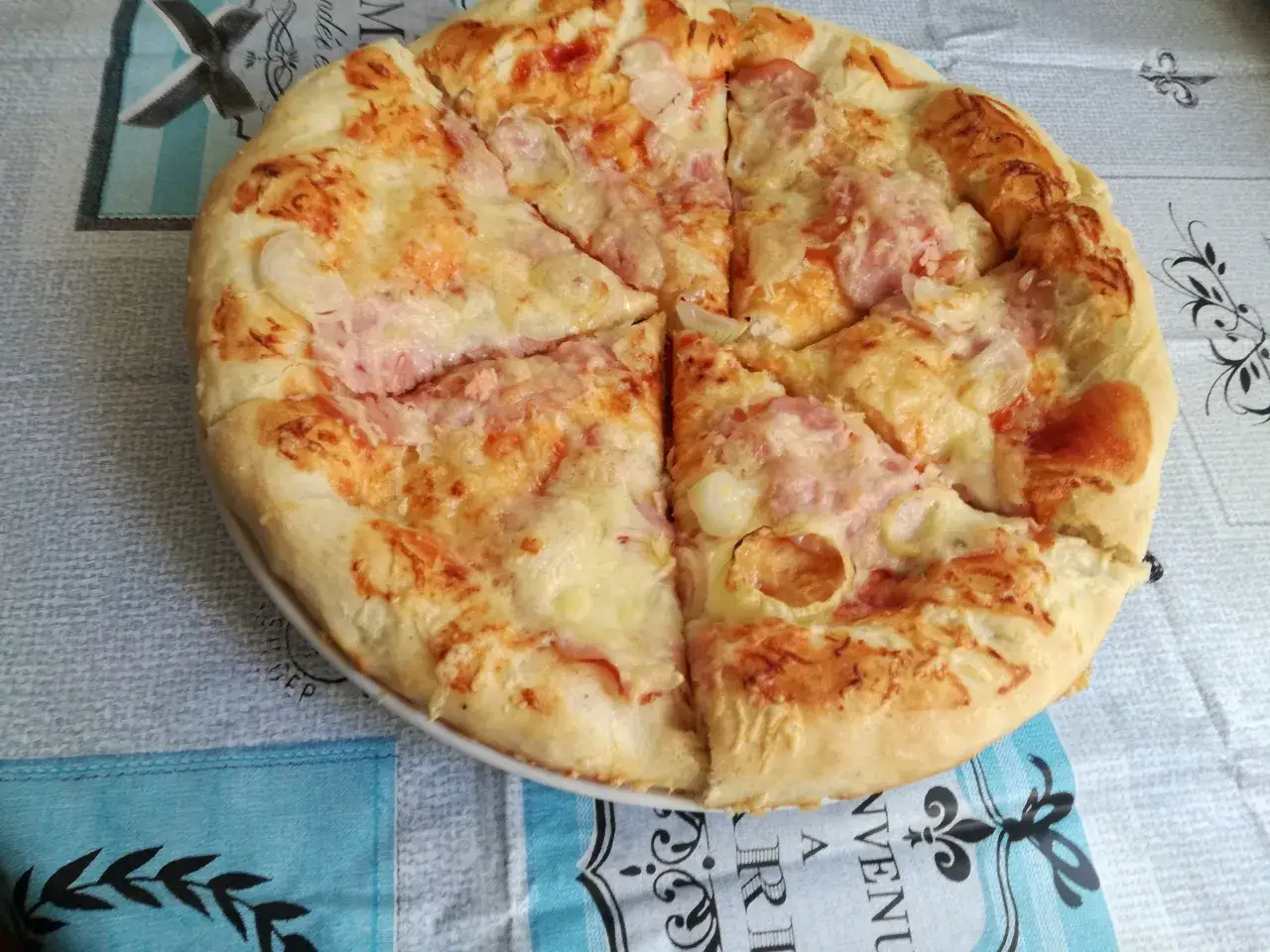 Pyszna pizza z serem i kawałkami szynki, idealna na szybki obiad. Jaka szynka na pizzę? Ta wygląda świetnie!